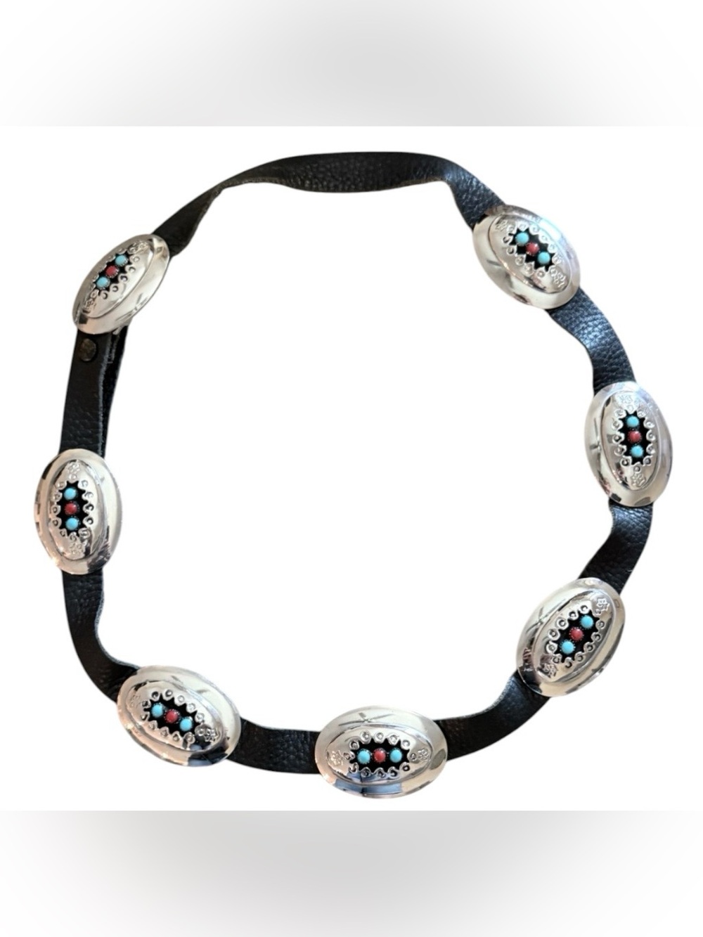Vintage style western leather belt featuring oval silver tone metal conchos